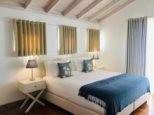 米尔芳提斯城Guarda Rios的卧室配有一张带蓝色床单和枕头的大型白色床。