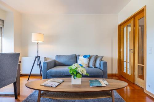 波尔图Foz Premium Retreat的客厅配有蓝色的沙发和茶几