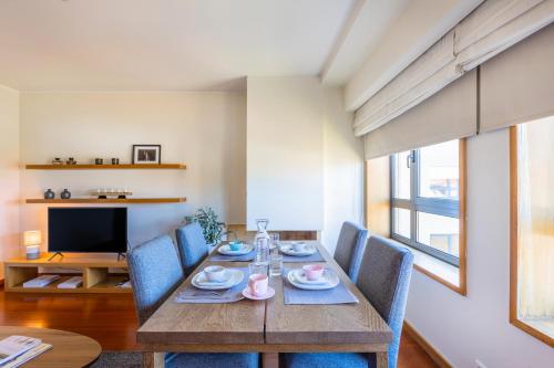 波尔图Foz Premium Retreat的一间带木桌和蓝色椅子的用餐室