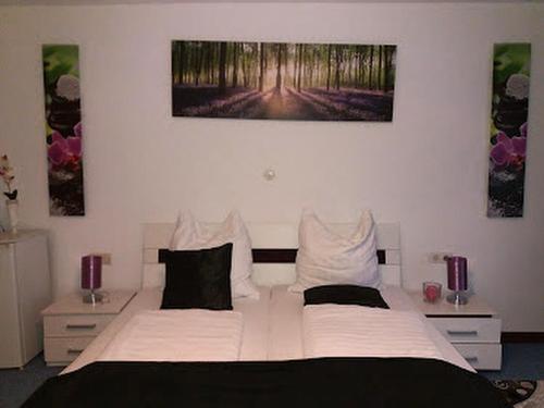 巴特欧波Hotel Restaurant Toscana的卧室配有一张白色大床,墙上挂有两幅画作