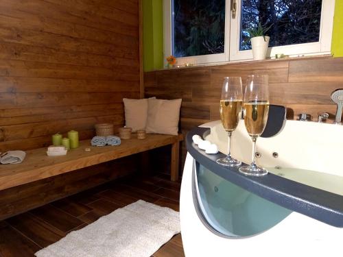 弗济内Apartman Nada的浴室设有浴缸,备有两杯香槟