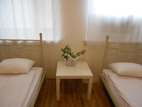 于韦斯屈莱Anne's City Apartment的一间设有两张床的房间和一张鲜花桌子