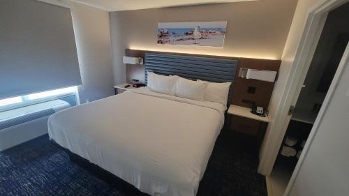巴拿马城温德姆巴拿马城区林恩避风港温盖特酒店的酒店客房带一张大床,带白色床单