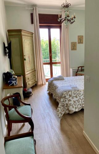 蒙扎Al Giardino Segreto的卧室配有床、椅子和窗户。