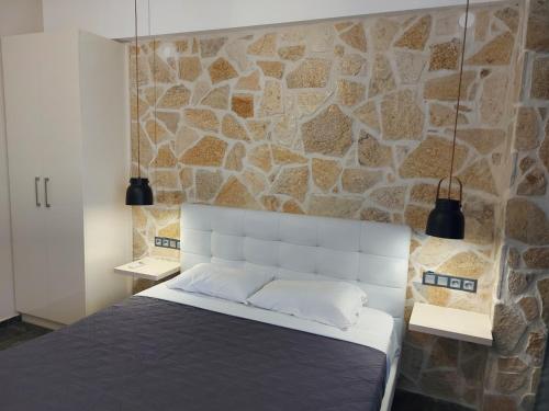 阿默达拉-伊拉克利翁The Santo George Beach Resort的一间卧室设有石墙和一张床