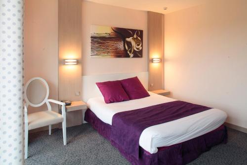 帕塞南Domaine du Revermont - Logis Hotel的配有一张床和一把椅子的酒店客房
