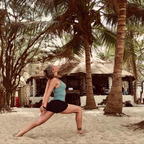 SanyangJungle Beach Resort的一名在海滩上做瑜伽姿势的女人