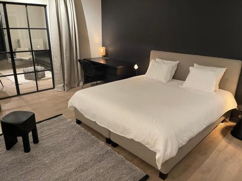 根特Unique luxury apartment with cosy garden!的卧室配有一张白色大床和一张书桌