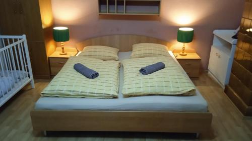 LendakApartmán Kristínka的一张带两个枕头的床和两盏灯