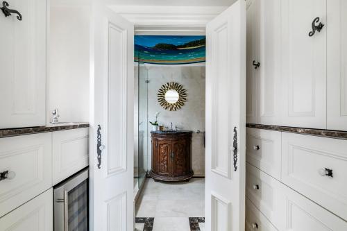 悉尼Tusan Villa Little Manly的厨房配有白色橱柜和镜子