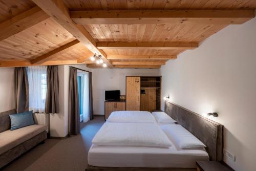 塞尔瓦迪加尔代纳山谷Hotel Monte44的一间设有两张床和一张沙发的房间