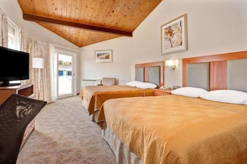 米尔谷米尔谷/索萨利托温德姆旅程住宿的一间酒店客房,设有三张床和一台平面电视