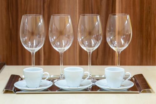 维斯普雷姆Hostel Mayer Superior Veszprém的桌上的盘子上放着四杯酒和杯子
