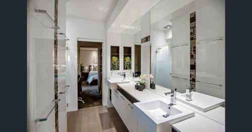 马奇Red Lotus Guesthouse的白色的浴室设有两个盥洗盆和镜子