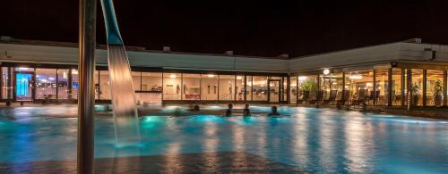 巴德楚尔察赫Dorint Parkhotel Bad Zurzach的一座晚上设有游泳池的建筑