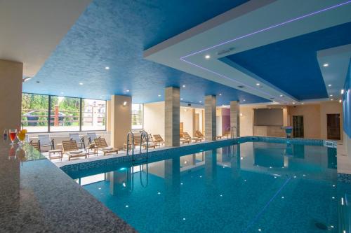 兹拉蒂博尔Hotel Agape的蓝色天花板的酒店游泳池