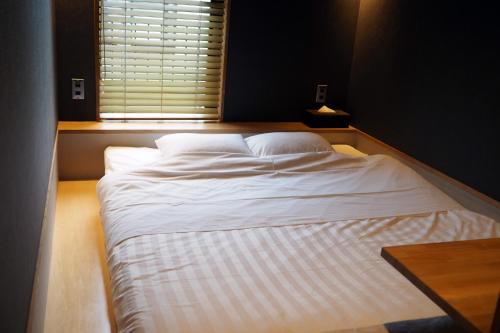 箱根MIRAHAKONE汤本站酒店的窗户客房内的一张大白色床