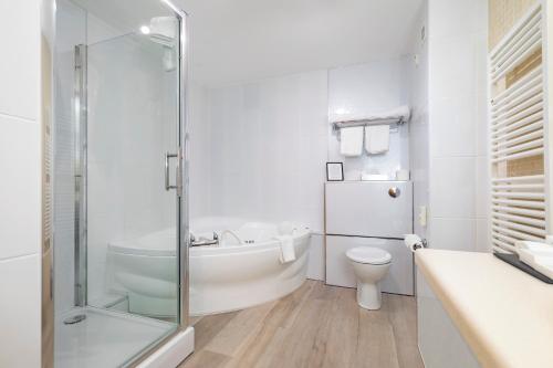 布什米尔斯湾景酒店的白色的浴室设有浴缸和卫生间。