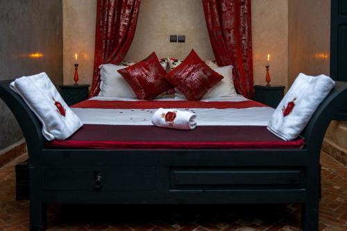 马拉喀什Riad L'Orchidée Suites & Spa的一张带红色和白色枕头的床