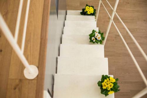拉泰尔扎Perry Loft的白色的楼梯,花朵黄色和绿色
