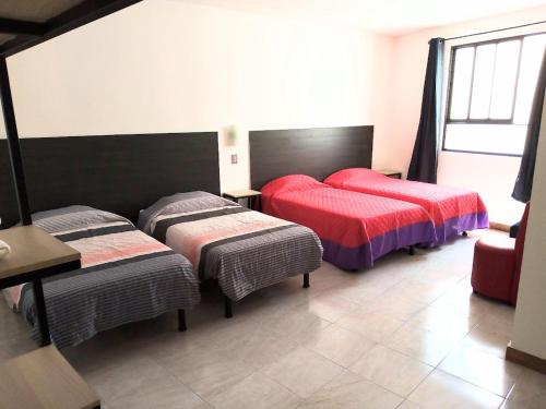 莱昂Casa Republik的一间卧室配有两张床和一张桌子及椅子