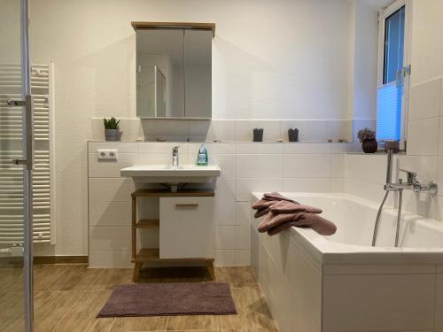 霍恩斯泰因Ferienwohnung Sonnenblick的白色的浴室设有浴缸和水槽。