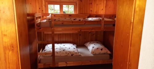 莱莫斯Chalet bois soleil的配有三张双层床的木制客房内的双层床