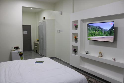 Ţarīfفندق زيلامسي的卧室配有一张床和壁挂式平面电视。