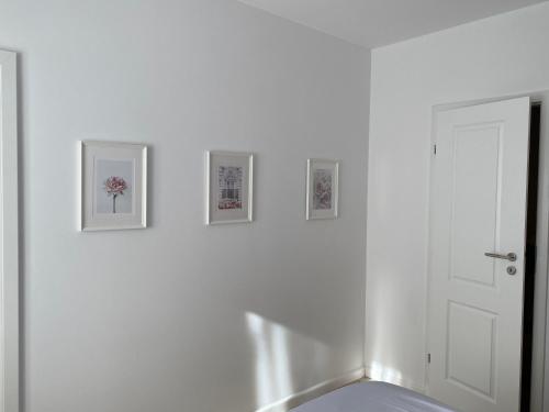 布加勒斯特Magheru cozy new apartament 2 rooms的白色的房间,墙上有三张照片