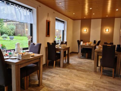 埃伦茨-波尔特斯多夫葡萄牙格斯宾馆的用餐室配有木桌和椅子