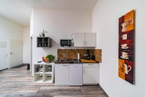 腓特烈港ApartmentFinke 3 an der Messe Friedrichshafen的厨房配有白色橱柜和柜台。