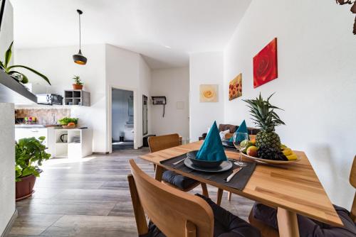 腓特烈港ApartmentFinke 3 an der Messe Friedrichshafen的用餐室配有带水果的木桌