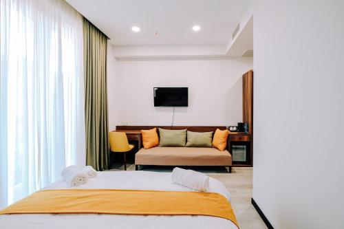 第比利斯多喜酒店的一间卧室配有一张大床和一张沙发