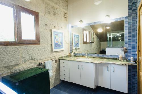 托米尼奥Villa Casa de Campo Los Carballos的一间带水槽和镜子的浴室