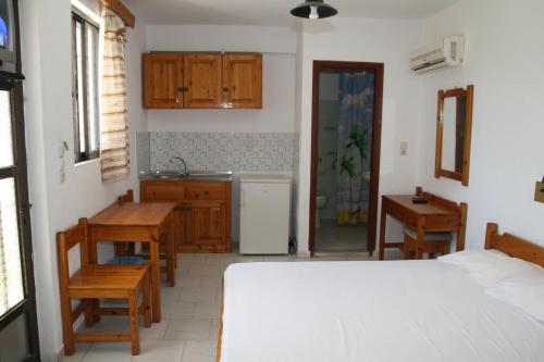 卡尔扎迈纳安达维斯酒店的一间卧室配有一张床铺和一张桌子,还设有一间厨房