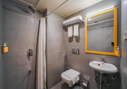 孟买Bloom Hotel - Worli South Mumbai的一间带水槽、卫生间和镜子的浴室