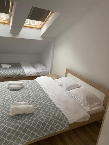 普里什蒂纳Pristina Select Apartments的一间卧室配有两张带毛巾的床