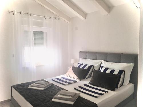 维斯Ada Vis Apartments的一间卧室配有一张带黑白枕头的床