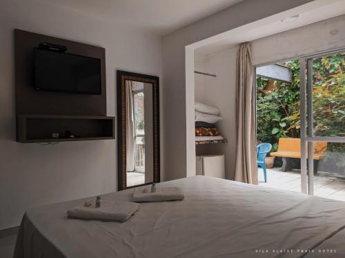 巴拉韦利亚Vila Alaide Praia Hotel的一间卧室配有一张床、镜子和窗户