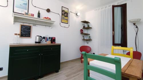 都灵B&B Borgo Vanchiglia的厨房配有绿色橱柜和桌子