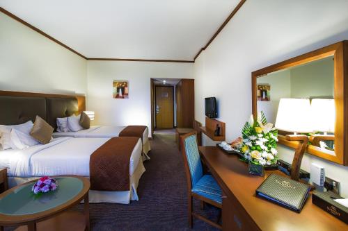 迪拜Landmark Summit Hotel的酒店客房配有两张床和一张书桌