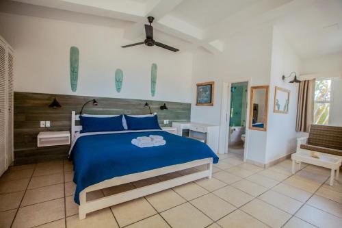 库尔克岛Treetops Hotel的一间带蓝色床的卧室和一间浴室