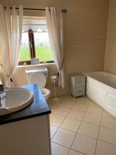 莫纳汉Gallagh Guest House self catering h18r252 Eircode的带浴缸、卫生间和盥洗盆的浴室
