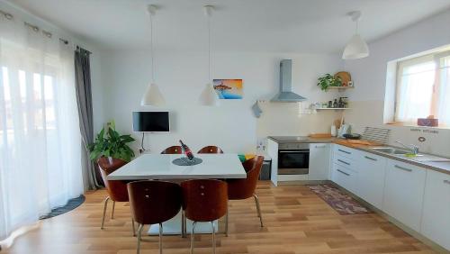 巴莱Rooms and Apartments IstraSoley的厨房配有白色的桌子和一些椅子