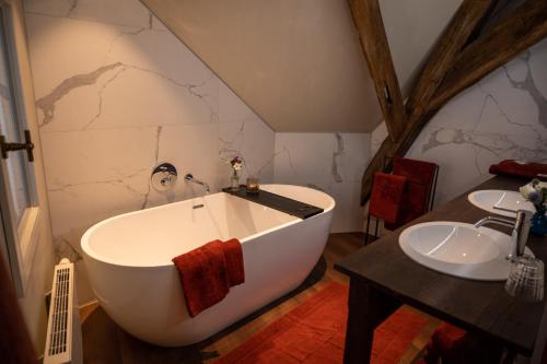 布鲁日B&B l'histoire de l'éclair的一间带大浴缸和水槽的浴室