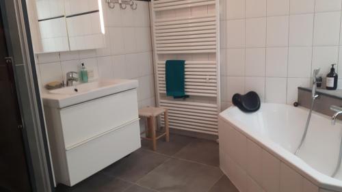 阿纳姆维佐格德卡莫茵莫努门特庞德旅馆的白色的浴室设有水槽、浴缸和淋浴。