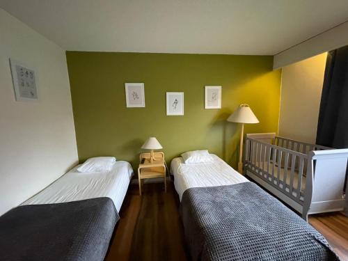 普达斯耶尔维hotelli ravintola kurenkoski的配有2张单人床的客房 - 带1张婴儿床
