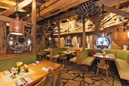 贝希特斯加登布切霍阿尔普住宿酒店的餐厅设有桌椅和木墙