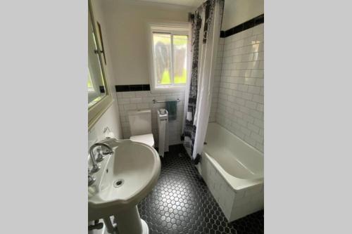 曼纳姆Kitty Spain's Cottage的浴室配有盥洗盆、卫生间和浴缸。