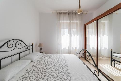 滨海弗兰卡维拉L'approdo di Ermione的一间白色卧室,配有两张床和窗户